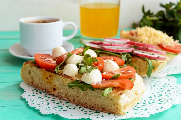 Tostadas con tomate, perlas de mozzarella y rúcula